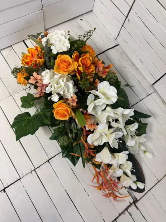 Elegancki stroik nagrobny z białymi mieczykami, magnolią i pomarańczowymi różami