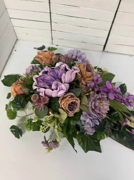 Obciążony stroik nagrobny w kształcie łezki z magnoliami.